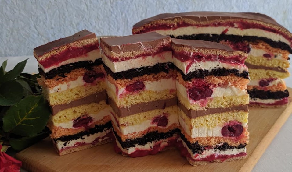 Пляцок “Волинські візерунки”Коржі
Форма 25Х35 см. Подвійні коржі. Шоколадне тісто: 2 яйця, 2 ст. ложки цукру, 1 ст. ложка борошна, 50 г какао, 1 ч. ложка розпушувача. Рожеве тісто: 2 яйця, 2 ст. ложки цукру, 1 ст. ложка борошна, 1 п. вишневого киселю, 1 ч. ложка розпушувача. Продукти на 1 корж – треба 2.
Шоколадне тісто. Відділити білки від жовтків. Збити білки з цукром до стійких піків, додати жовтки та продовжувати збивати до пишної маси. Борошно, розпушувач і какао просіяти та додати до до яєчної маси. Ретельно, але акуратно вимішати. Тісто виходить досить густим. Рожеве тісто. Приготувати за тим же принципом, що й шоколадне.
У форму, вистелену пергаментом, викласти шоколадне тісто, вирівняти та вилити рожеве тісто. Випікати при температурі 180C 25-30 хв. Потрібно зробити ще один такий корж.
Сметанні коржі. 2 яйця, 1 скл. цукру, 20 г ванільного цукру, 4 скл. борошна, 2 ч. ложки розпушувача, 1 скл. сметани, 2 ч. ложки какао. 
Яйця збити з цукром та ванільним цукром (віничком). Додати сметану і продовжувати збивати. Досипати просіяне борошно та порошок до печива і замісити тісто. Розділити його на дві частини, до однієї додати какао. Кожну частину ще раз поділити навпіл, щоб вийшло дві темні та дві світлі кульки. Залишити в холодильнику на 1-2 год. З кожної кульки розкотити коржі, викласти у форму, вистелену пергаментом та випікати приблизно 10 хв при температурі 180 ОC (орієнтуйтеся на свою духовку).
Крем
Заварний крем. 600 мл молока, 1 ст. ложка з чубком борошна, 2 ст. ложки з чубком крохмалю, 170-200 г цукру, 10 г ванільного цукру, 300 г масла. 
З борошна, крохмалю, молока, цукру та ванільного цукру заварити масу, дати їй охолонути. Масло збити до білого кольору, додати заварну масу та продовжувати збивати до пишності.
Шоколадний крем. 350 г йогурту, 80-90 г чорного шоколаду, 20 г желатину, 60 г окропу.
Желатин залити окропом, ретельно перемішати. Розтопити шоколад, дати трохи охолонути, влити до йогурту, розмішати. Додати желатин та знову перемішати.
Вишневий курд: 350 г вишень без кісточок, 2 яйця, 120 г цукру, 50 г масла, 2 ст. ложки лимонного соку, 12 г крохмалю. 
До вишень додати лимонний сік та перетерти в блендері. Поставити на вогонь та дати покипіти 2 хв. Зняти з вогню. Яйця збити з цукром, додати крохмаль та ще трохи збити. Тонкою цівкою, постійно помішуючи, влити вишневу масу. Добре перемішати. Поставити на вогонь та варити 3-4 хв до загустіння. Дати охолонути. Масло збити та додати вишневу масу, збивати на невеликій швидкості.
Як зібрати пляцок
Темний сметанний корж.
Курд.
Заварний крем.
Подвійний корж.
Заварний крем + вишні (жменька).
Світлий сметанний корж.
Шоколадний крем.
Світлий сметанний корж.
Заварний крем + вишні (жменька).
Подвійний корж.
Заварний крем.
Курд.
Темний сметанний корж.
Зверху можна змастити кремом та прикрасити за бажанням.
Авторський рецепт і фото Юлії Якіб’юк